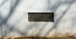 Grille de ventilation sur mur extérieur, soulignant un problème potentiel d'étanchéité vide sanitaire